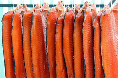 Immagine di filetti di salmone affumicato Coda Nera appesi per l'affumicatura