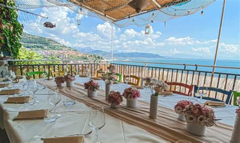 Terrazza di un ristorante con vista sul mare al tramonto.