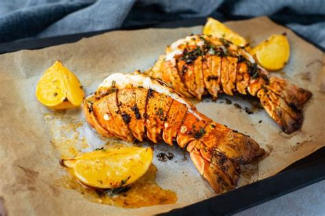 Aragosta al forno pronta per essere servita, con limone e erbe aromatiche.