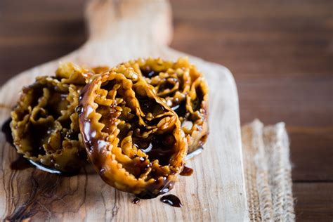 Primo piano di Cartellate pugliesi immerse nel miele e decorate con confettini colorati