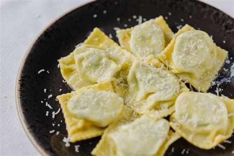 foto ravvicinata di tortelli d'erbetta fatti a mano, conditi con burro e parmigiano