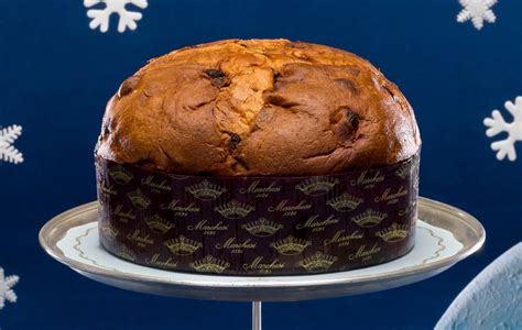 Una selezione di panettoni artigianali con diverse guarnizioni e impasti, disposti su un tavolo festivo.