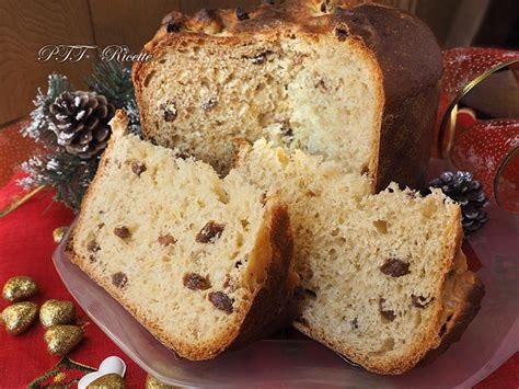 Un primo piano di una fetta di panettone con uvetta e canditi visibili.