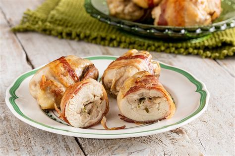 Una selezione di ingredienti freschi per preparare gli involtini di pollo: petto di pollo, prosciutto cotto, formaggio, erbe aromatiche.