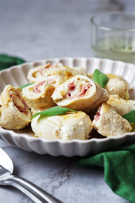 Dettaglio della farcitura degli involtini di pollo con prosciutto e formaggio, pronti per essere arrotolati.