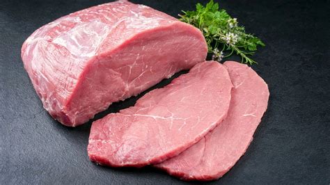 Immagine di fettine di vitello pronte per essere cucinate, con ingredienti a lato: prosciutto, mozzarella, farina.