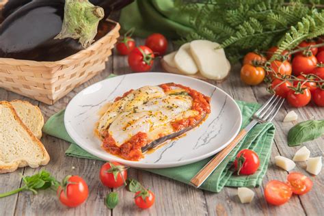 Immagine di una parmigiana di cernia e melanzane appena sfornata, con formaggio filante
