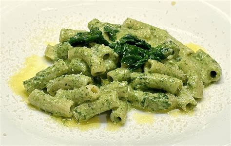 padella con pasta, spinaci e panna mentre vengono mescolati