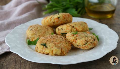 Un piatto con polpette di salmone e patate dorate, servite con una ciotolina di maionese alla menta.