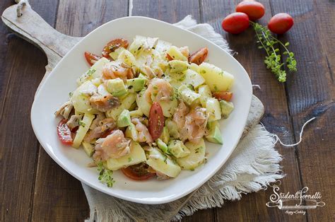 Un'insalata estiva con patate a cubetti, salmone affumicato a pezzetti, olive verdi e condimento al limone.