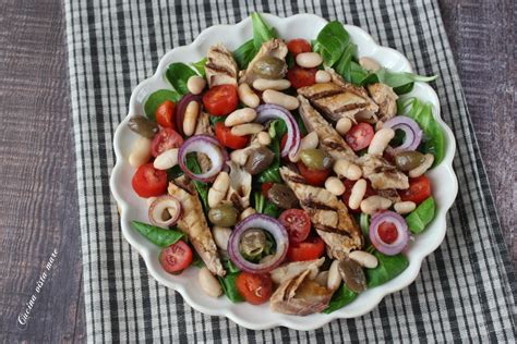Immagine di un piatto colorato di insalata di couscous con sgombro, melanzane grigliate e pomodorini freschi.