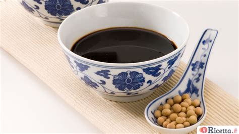 Ingredienti per la salsa: diverse bottiglie di salsa di soia, aceto nero, miele e zucchero disposti su un piano di lavoro.