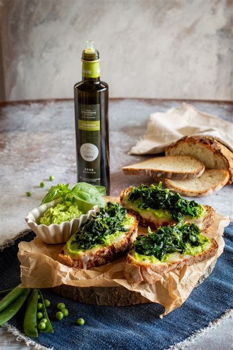 Immagine ravvicinata di crostoni di pane con crema di piselli, cicoria e pecorino fuso