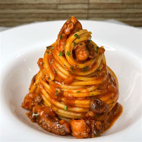 Immagine di spaghetti con ragù di polpo e guarnizione croccante