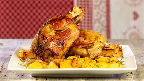 Immagine di uno stinco di maiale al forno con patate, che evoca un'atmosfera calda e accogliente.