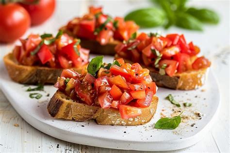 Varietà di pomodori freschi e pane rustico per la preparazione della bruschetta